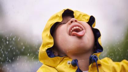 A child sticking tongue out during rain