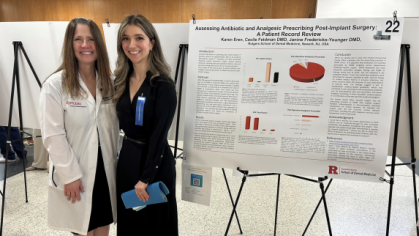 A student and faculty standing in front of a research poster.